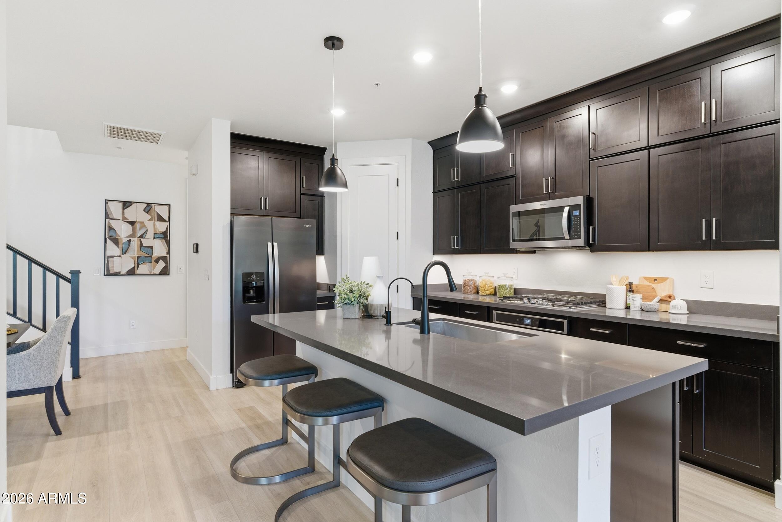 3855 South McQueen Road, Unit 34 Chandler, AZ 85286 - Photo 20 of 48 a kitchen with granite countertop stainless steel appliances a sink a stove and a refrigerator
