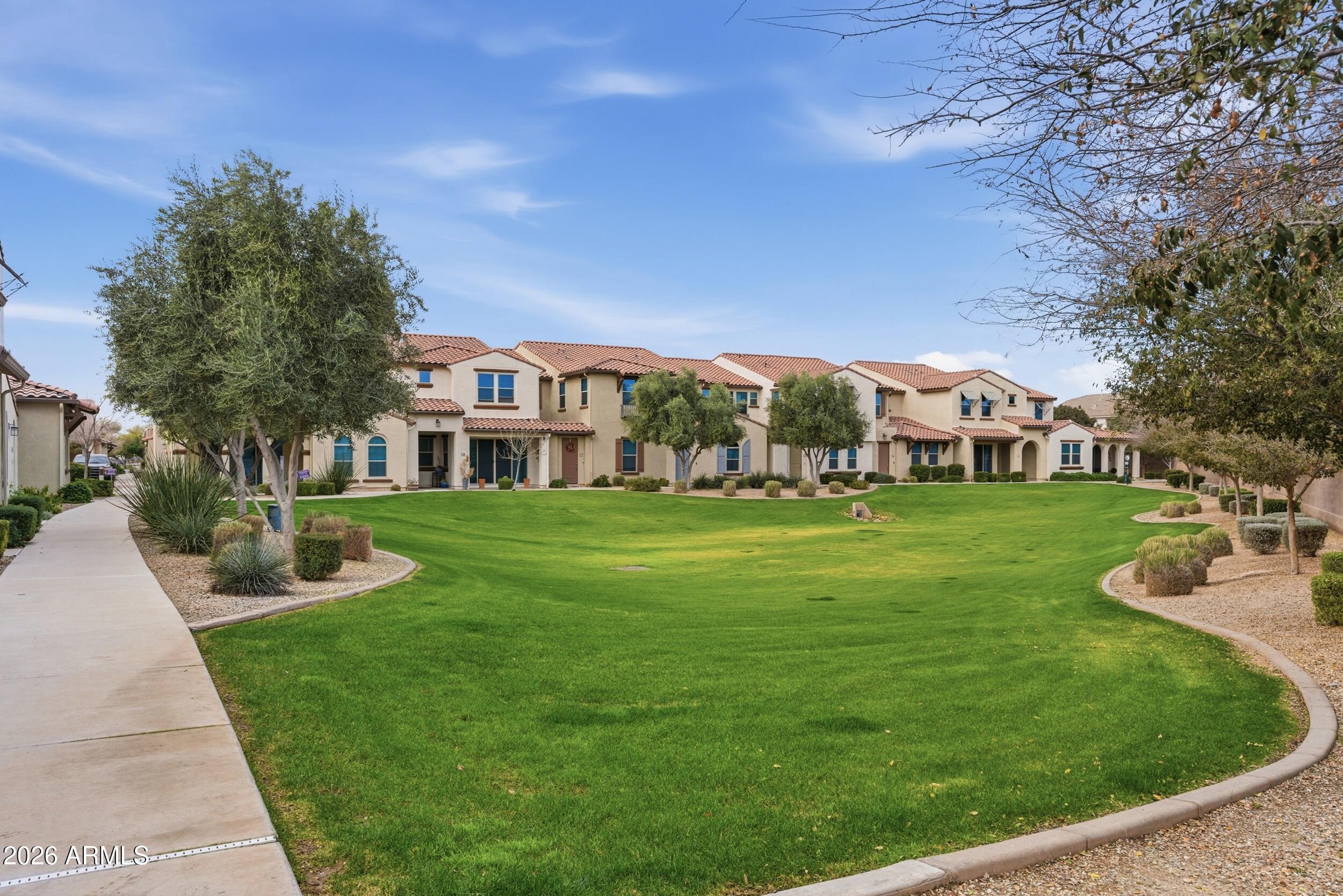 3855 South McQueen Road, Unit 34 Chandler, AZ 85286 - Photo 3 of 48 a view of a white house with a yard table and chairs