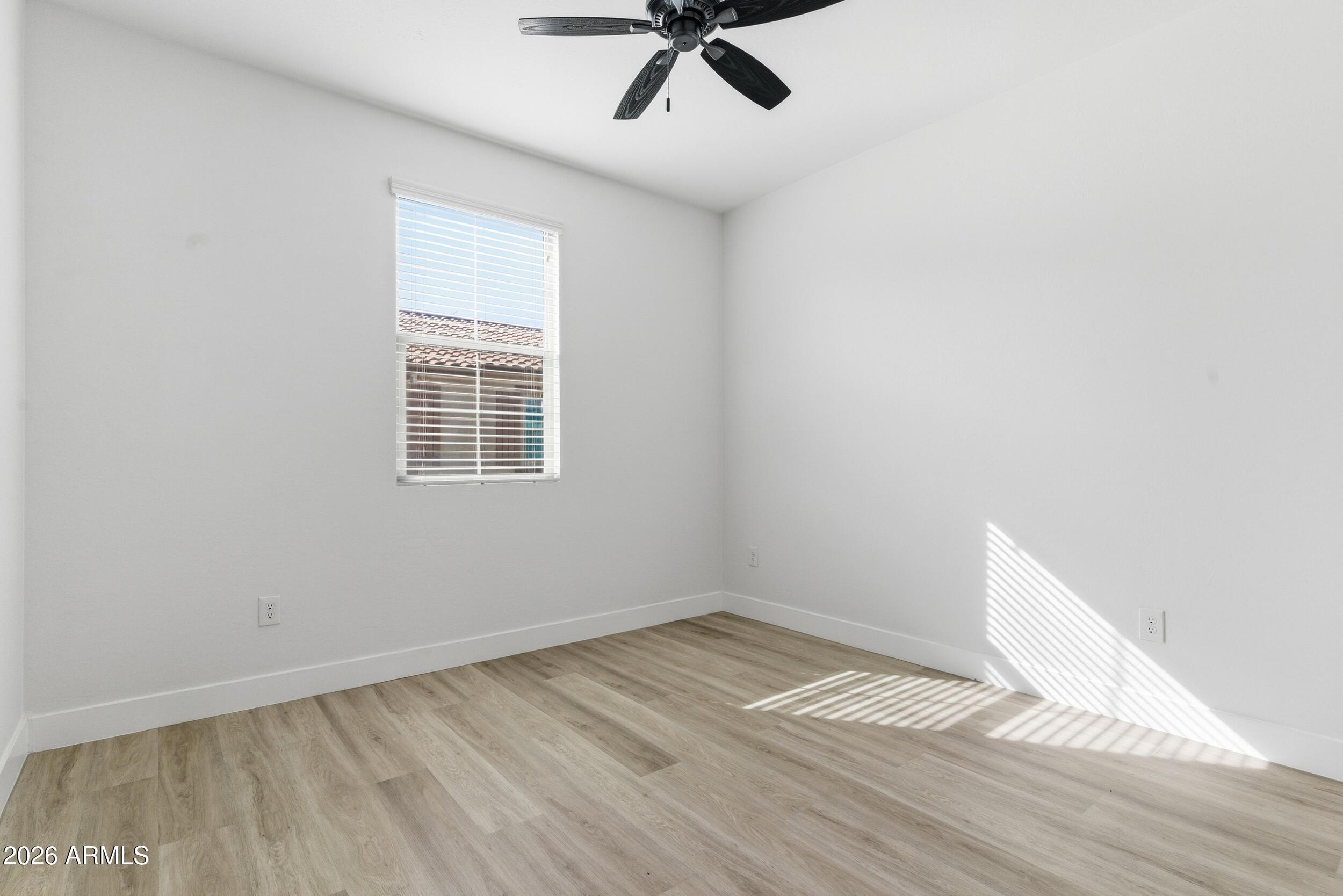 3855 South McQueen Road, Unit 34 Chandler, AZ 85286 - Photo 33 of 48 a view of empty room with wooden floor and fan
