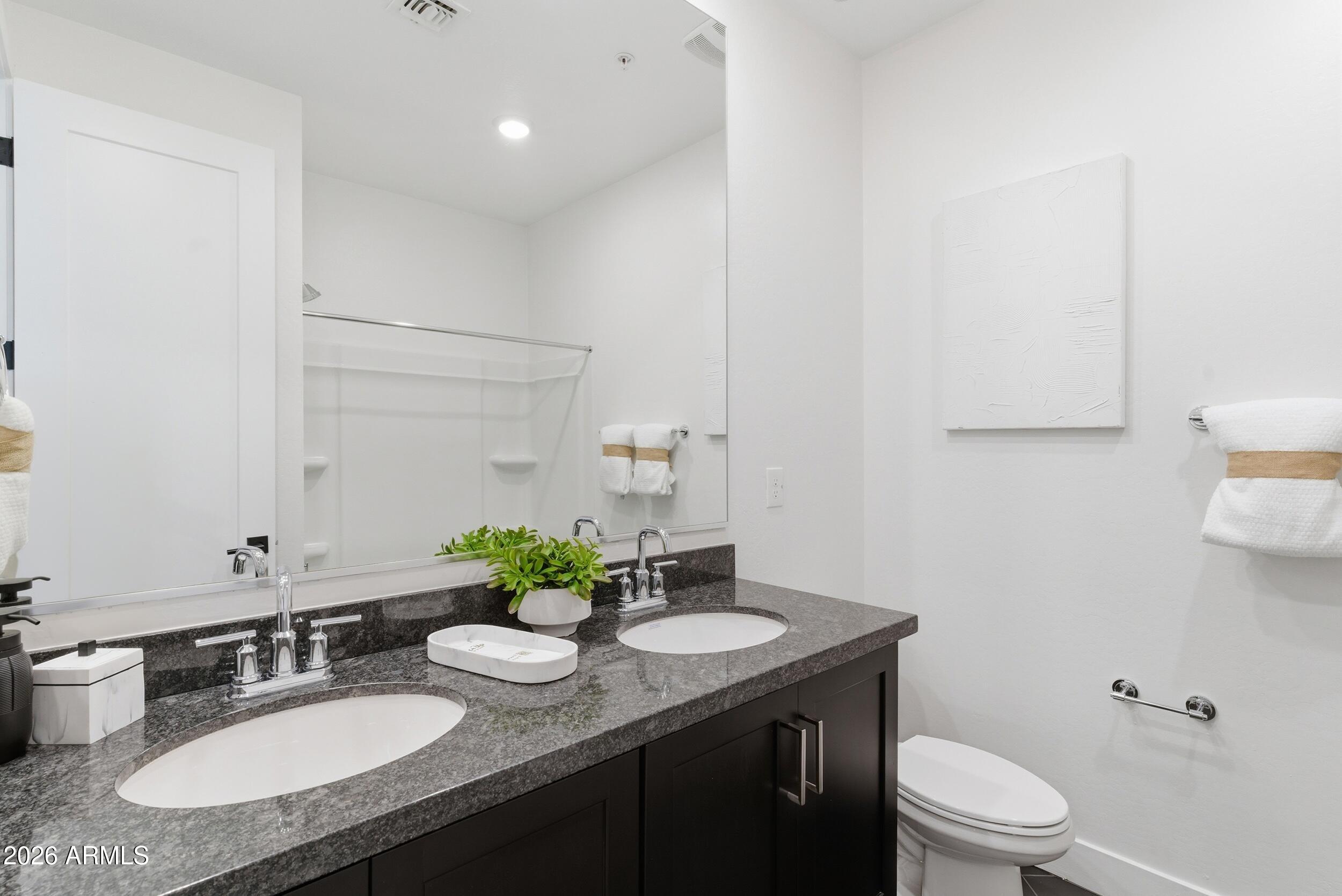 3855 South McQueen Road, Unit 34 Chandler, AZ 85286 - Photo 35 of 48 a bathroom with a granite countertop sink a toilet and mirror