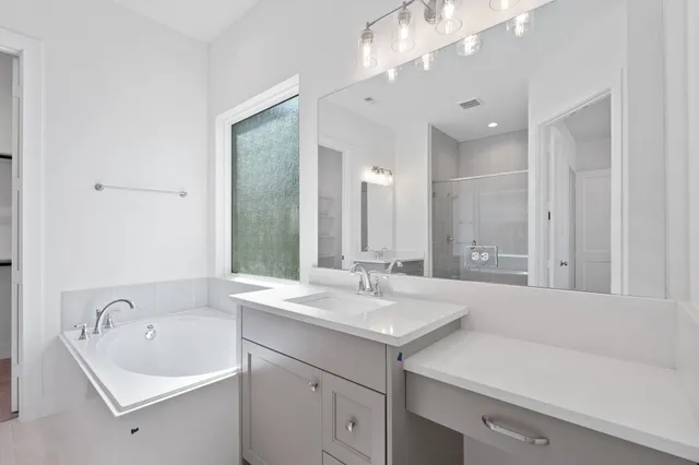 a bathroom with a bathtub sink and mirror