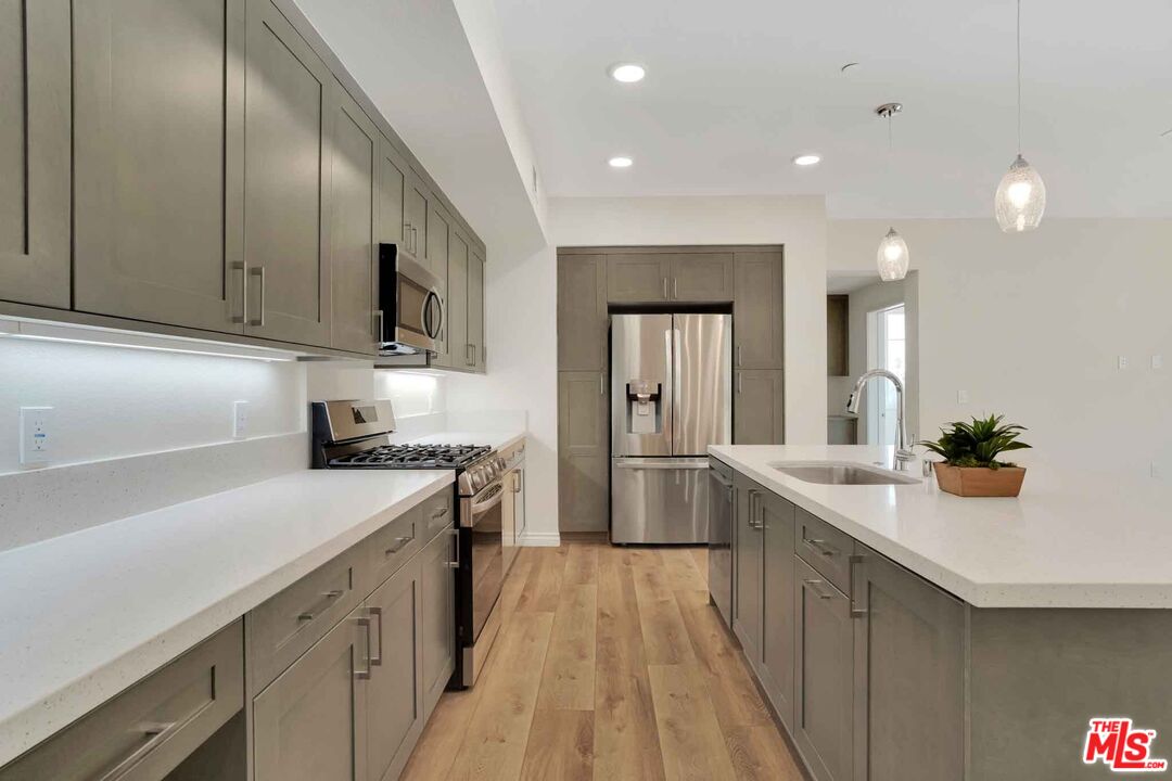 2850 Wagon Wheel Road, Unit 401 Oxnard, CA 93036 - Photo 11 of 31 a kitchen with a sink stove and cabinets