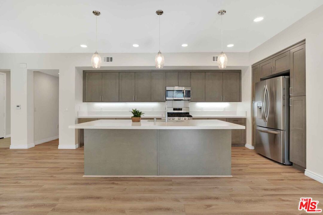 2850 Wagon Wheel Road, Unit 401 Oxnard, CA 93036 - Photo 14 of 31 a kitchen with kitchen island stainless steel appliances a sink and a refrigerator