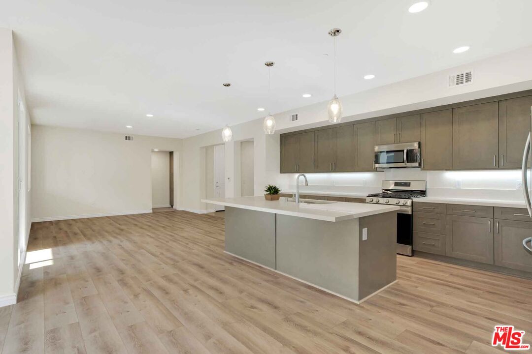 2850 Wagon Wheel Road, Unit 401 Oxnard, CA 93036 - Photo 15 of 31 a kitchen with stainless steel appliances granite countertop a sink and stove top oven