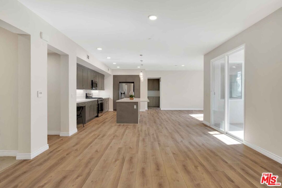 2850 Wagon Wheel Road, Unit 401 Oxnard, CA 93036 - Photo 8 of 31 a large kitchen with cabinets wooden floor and stainless steel appliances