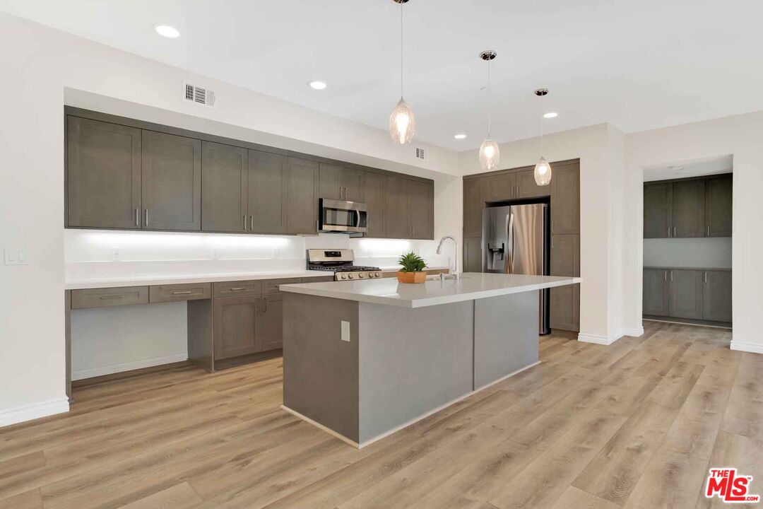 2850 Wagon Wheel Road, Unit 401 Oxnard, CA 93036 - Photo 9 of 31 a kitchen with a refrigerator and a stove top oven