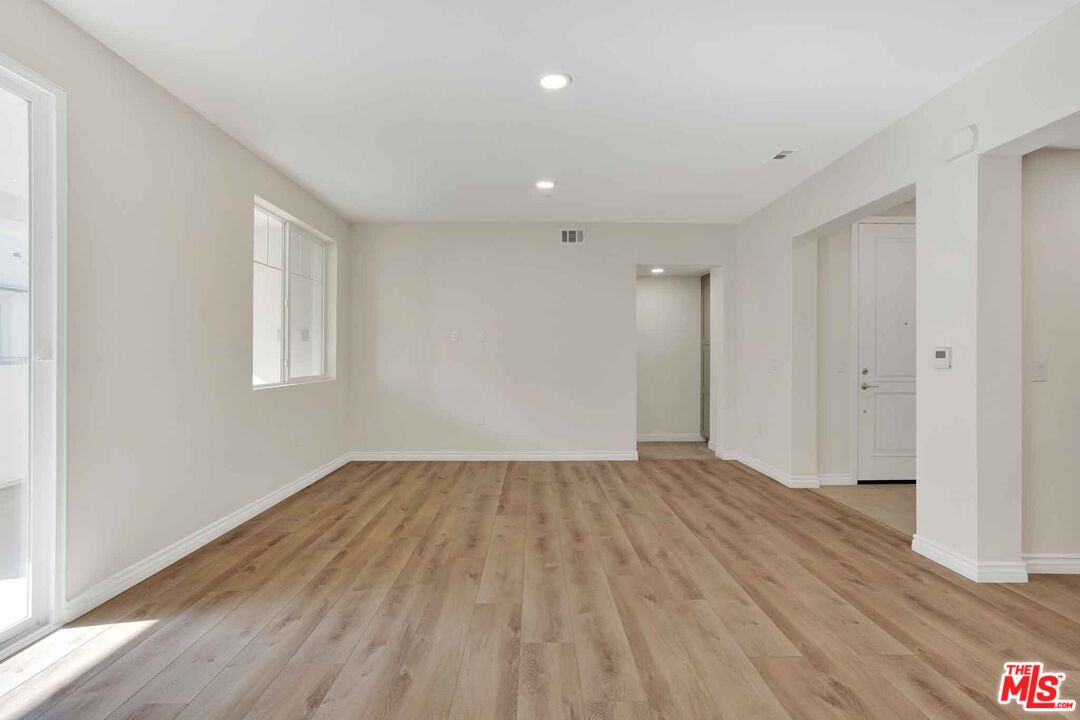 2850 Wagon Wheel Road, Unit 401 Oxnard, CA 93036 - Photo 10 of 31 a view of an empty room with wooden floor and a window