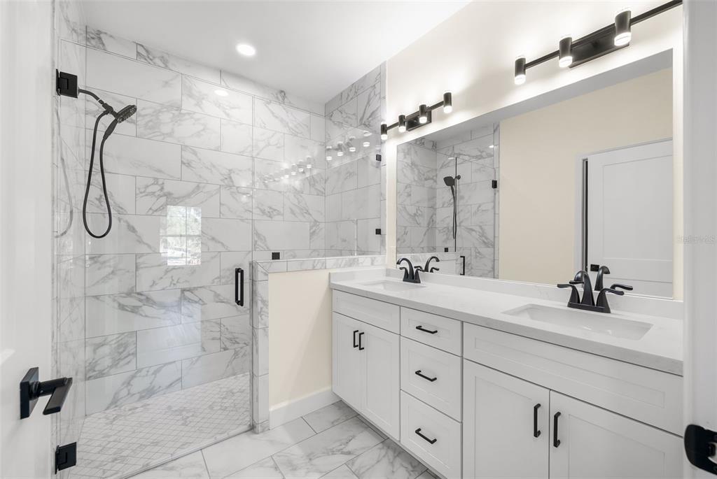 332 Southeast 3rd Avenue Melrose, FL 32666 - Photo 21 of 36 a bathroom with a double vanity sink mirror and shower