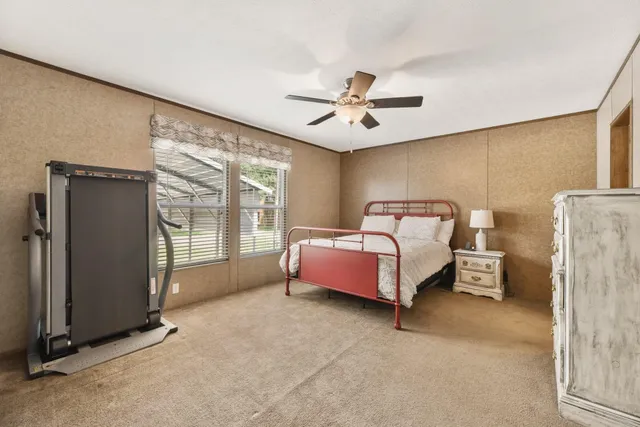 a spacious bedroom with a bed and large window