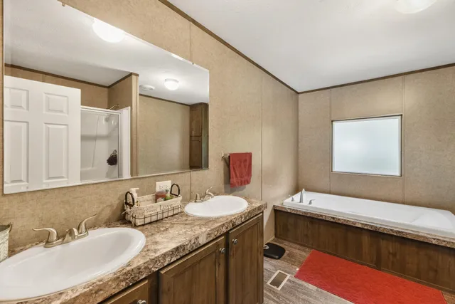 a bathroom with a granite countertop sink a large mirror and a bathtub