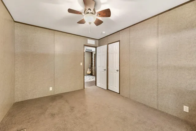 a view of an empty room and a ceiling fan