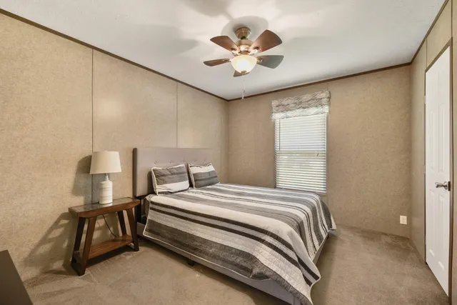 a bedroom with a bed and a ceiling fan