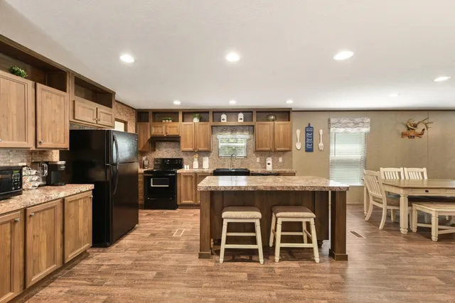 a kitchen with granite countertop a stove top oven and cabinets
