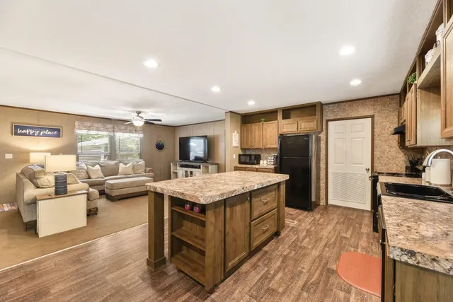 a kitchen with a stove a refrigerator and cabinets