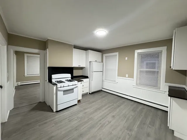 a kitchen with a stove and white cabinets