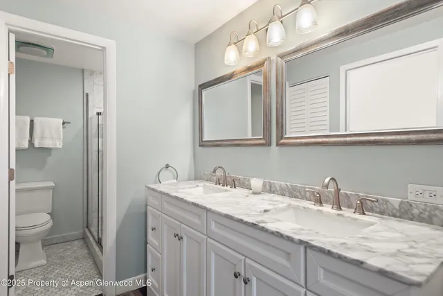 a bathroom with a granite countertop sink toilet and shower
