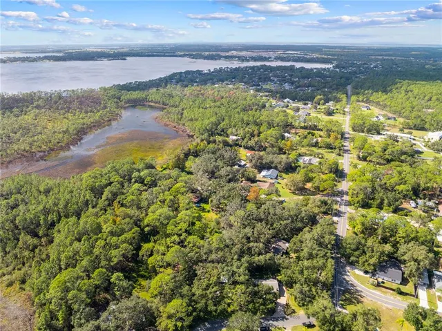 a view of a dining room and livingroom with furniture wooden floor a chandelier