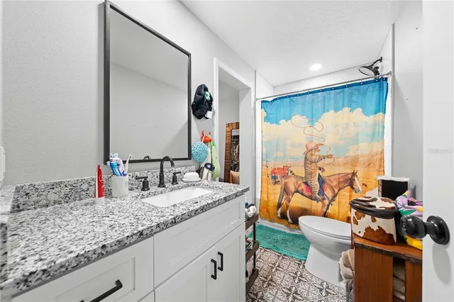 a kitchen with stainless steel appliances granite countertop a refrigerator oven a sink dishwasher and white cabinets with wooden floor