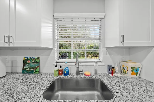 a kitchen with granite countertop a sink counter top space appliances and cabinets