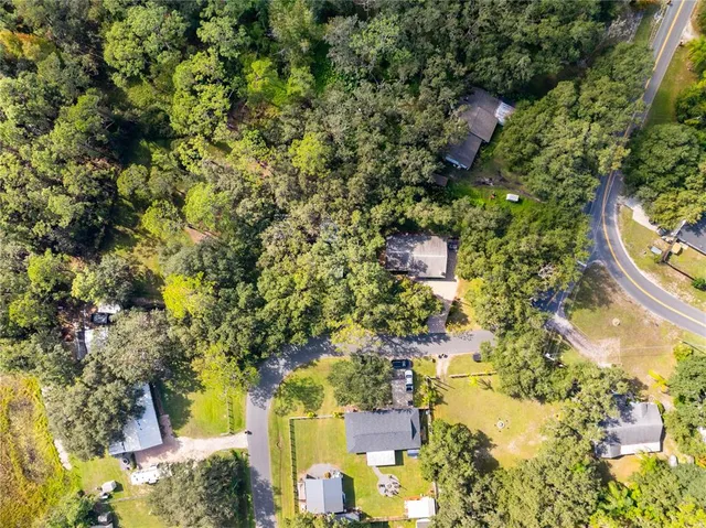 an aerial view of a house with a yard and lake view