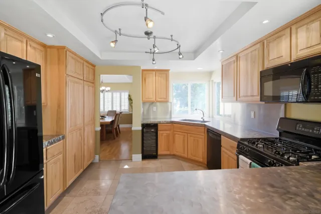 a large kitchen with stainless steel appliances granite countertop a stove refrigerator and microwave
