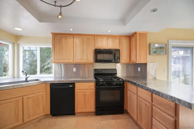 a kitchen with a sink stove top oven and cabinets