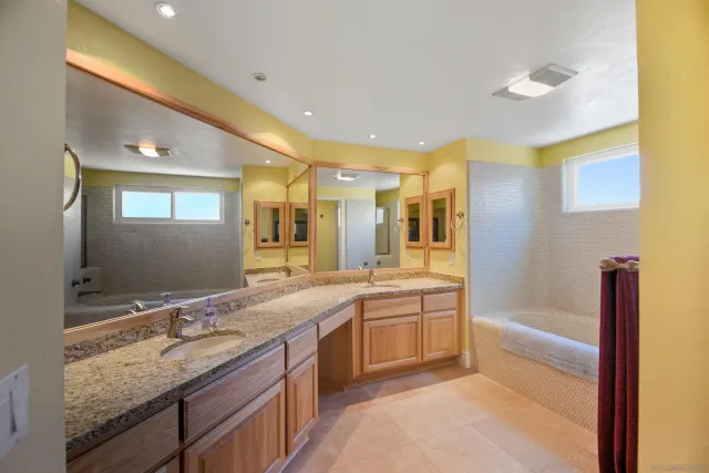 a spacious bathroom with a granite countertop sink and a mirror
