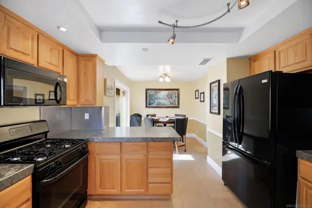 a kitchen with stainless steel appliances granite countertop a stove refrigerator and cabinets