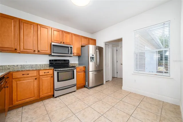 a kitchen with stainless steel appliances granite countertop a refrigerator stove top oven and sink