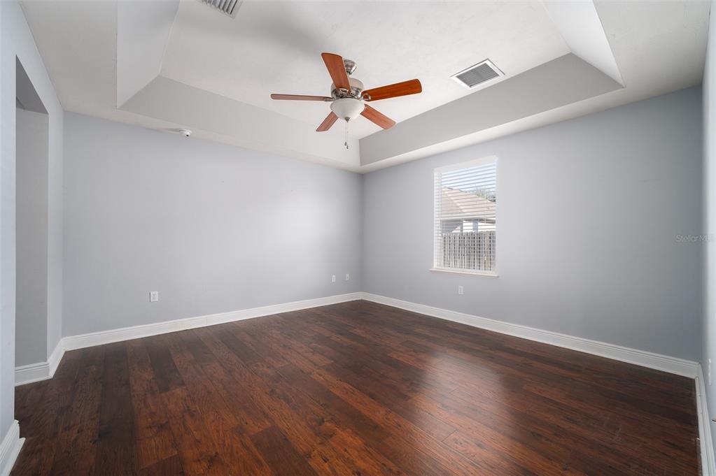 7931 Southwest 88th Street Gainesville, FL 32608 - Photo 15 of 35 an empty room with wooden floor ceiling fan and windows