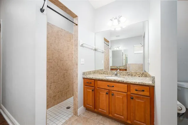 a bathroom with a granite countertop sink a mirror and a shower