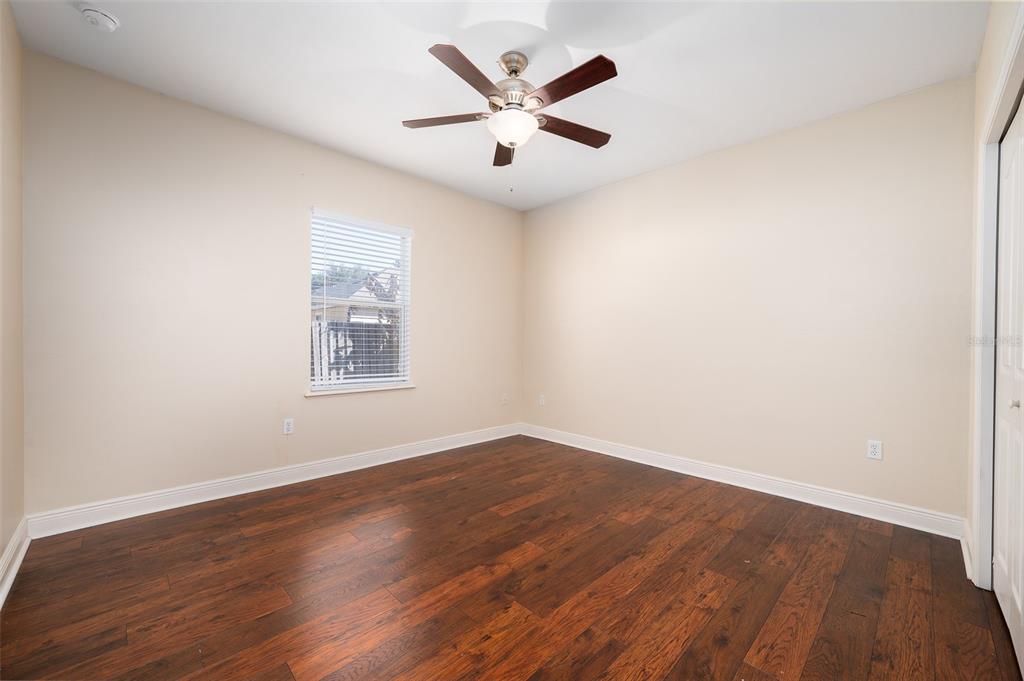 7931 Southwest 88th Street Gainesville, FL 32608 - Photo 24 of 35 an empty room with wooden floor and ceiling fan