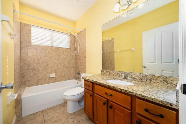 a bathroom with a granite countertop sink a toilet and bathtub