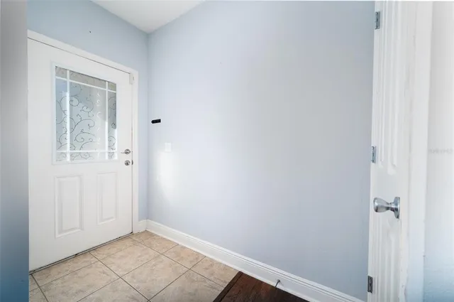 a view of an empty room with closet and a window
