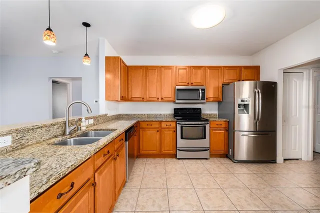 a kitchen with stainless steel appliances granite countertop a refrigerator and a sink