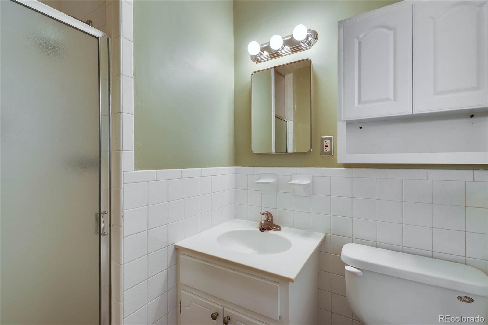 859 South Hudson Street Denver, CO 80246 - Photo 16 of 34 a bathroom with a toilet a sink and mirror