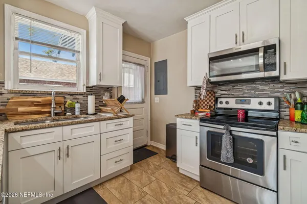 a kitchen with stainless steel appliances granite countertop a refrigerator and a stove
