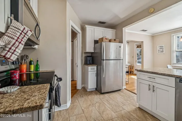 a kitchen with granite countertop white cabinets and white appliances