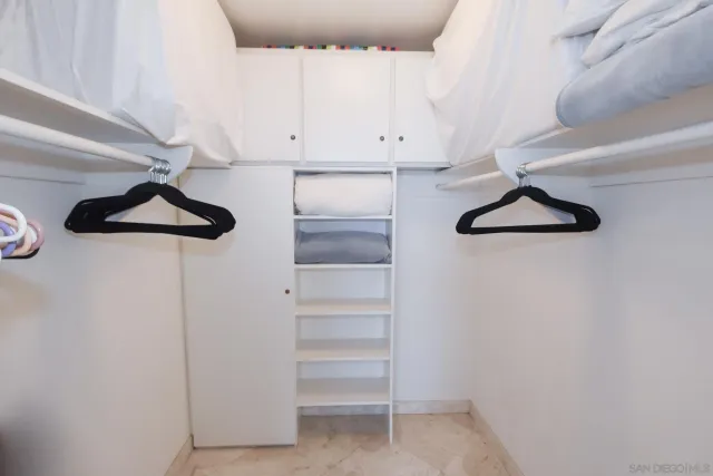 a view of cabinets and utility room with racks on wall