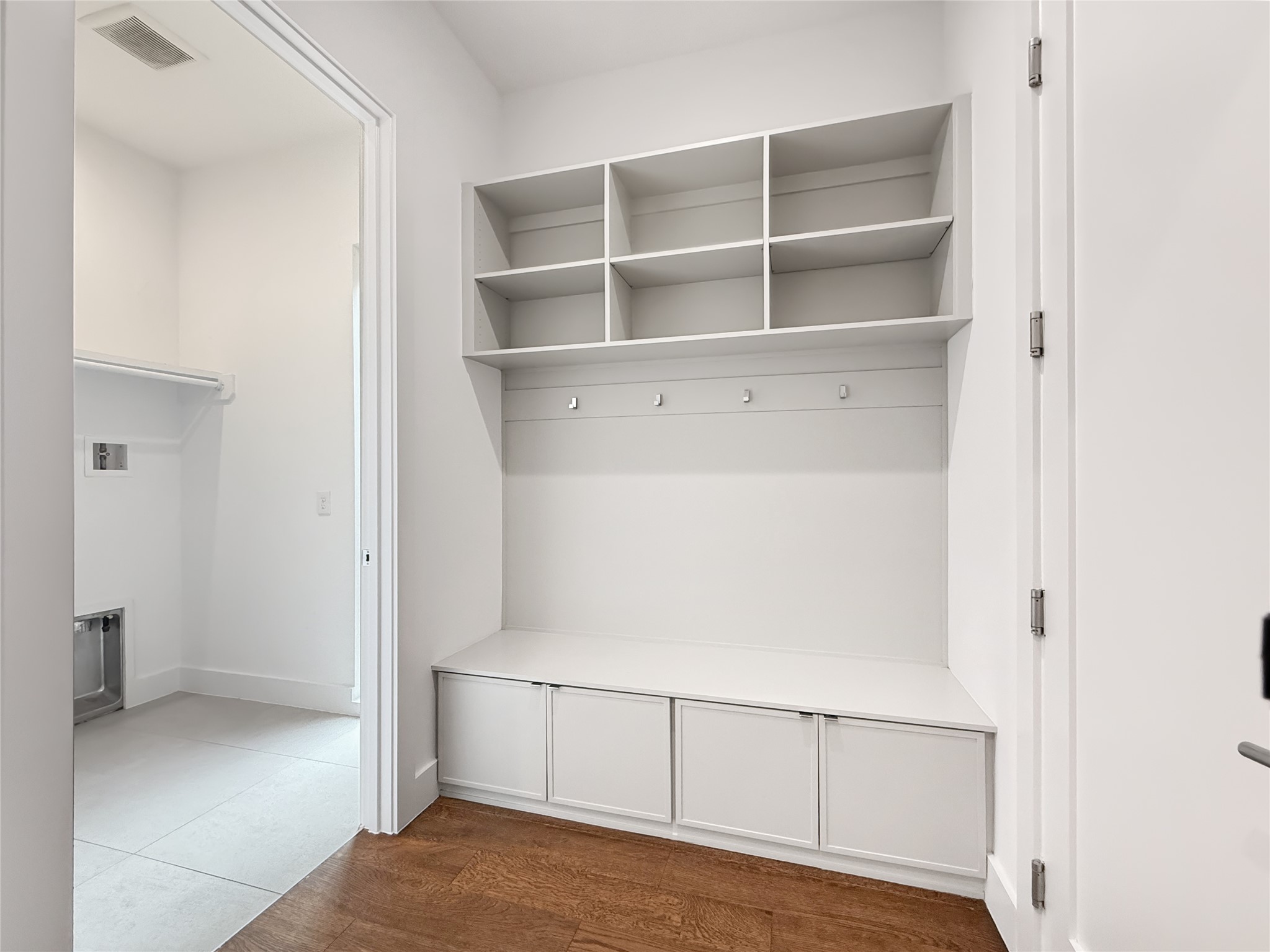 127 Frederick Street Austin, TX 78704 - Photo 21 of 34 Built-in mudroom storage featuring upper cubbies, coat hooks, and lower cabinetry with bench seating