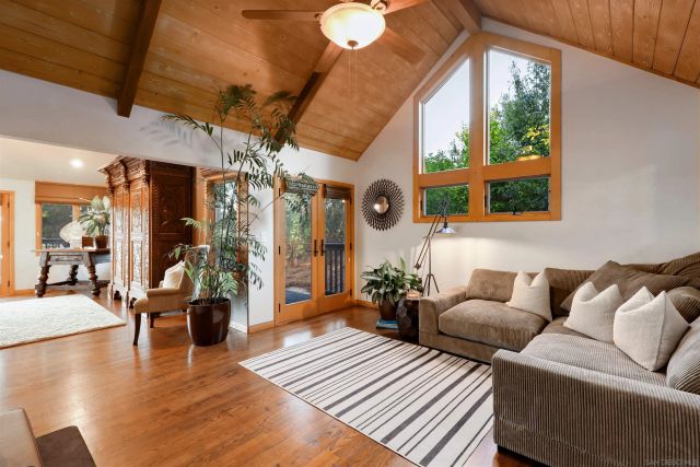 a living room with furniture a chandelier and a large window