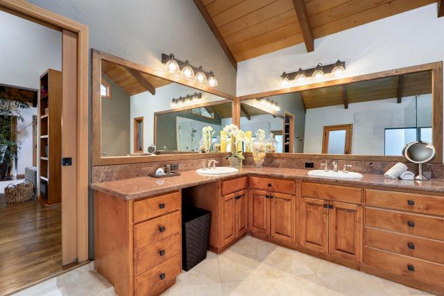 a spacious bathroom with a granite countertop sink a mirror and a shower