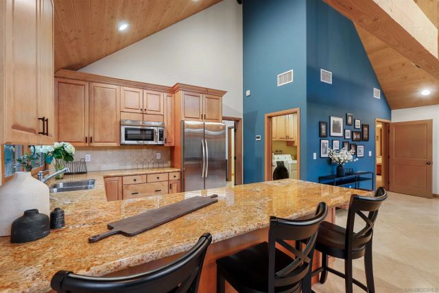 a kitchen with stainless steel appliances wooden floor dining table and chairs