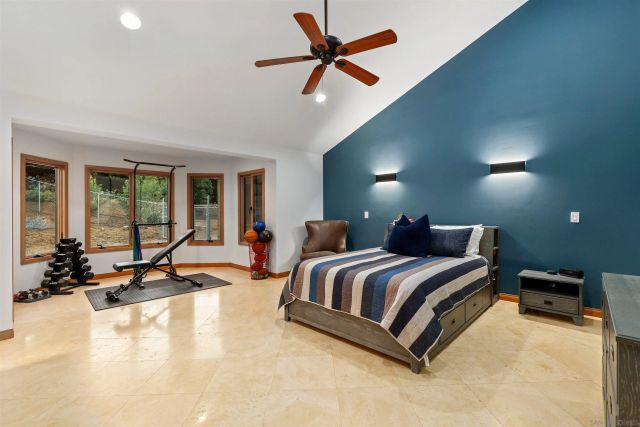 a spacious bedroom with a bed gym equipment and a large window
