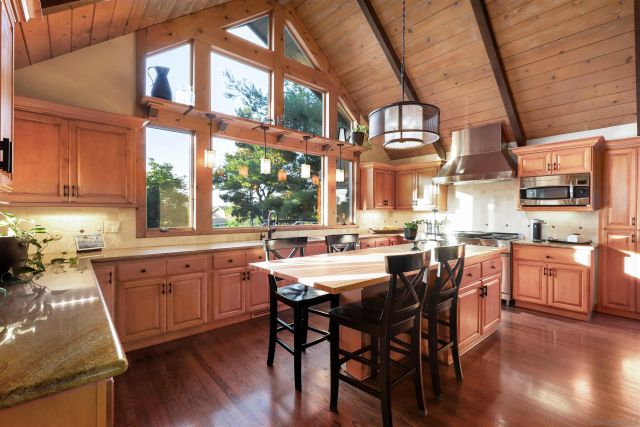 a kitchen with stainless steel appliances wooden floors and wooden cabinets