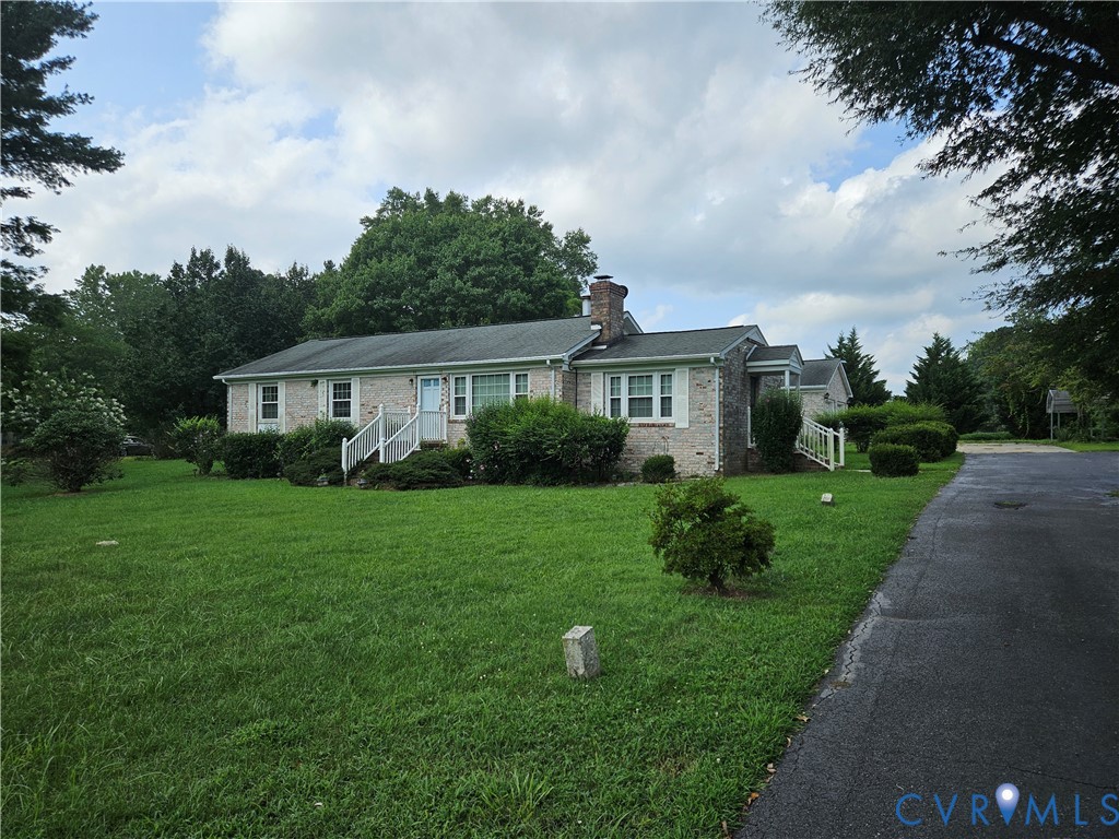 Ranch-style house featuring a front yard, a chimne