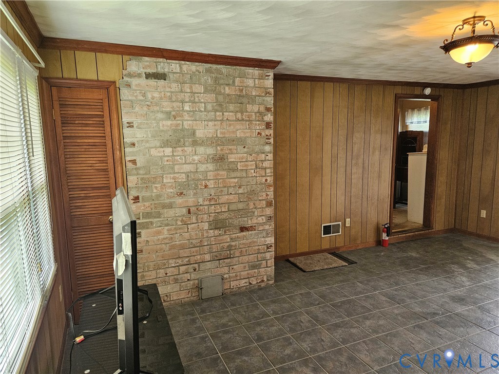 13336 Ladysmith Road Ruther Glen, VA 22580 - Photo 12 of 27 Empty room with wooden walls, dark tile patterned