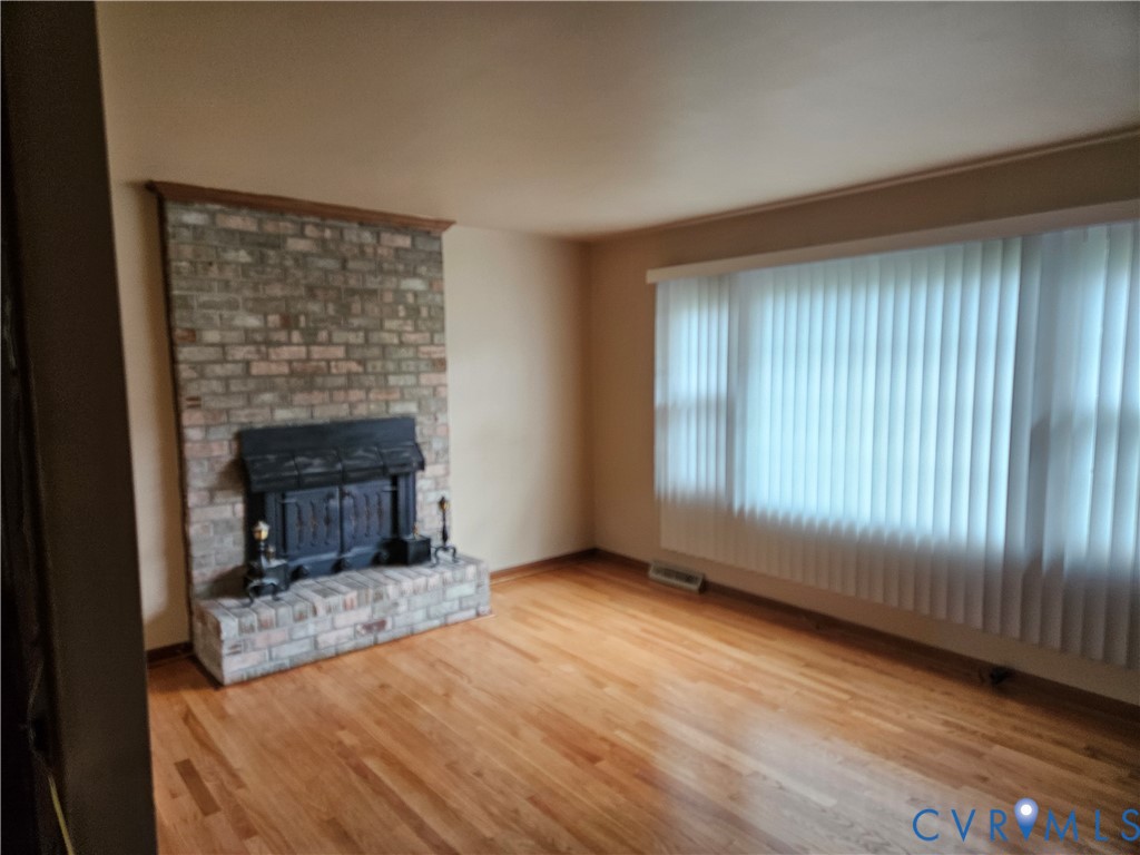 13336 Ladysmith Road Ruther Glen, VA 22580 - Photo 15 of 27 Unfurnished living room with a fireplace and wood