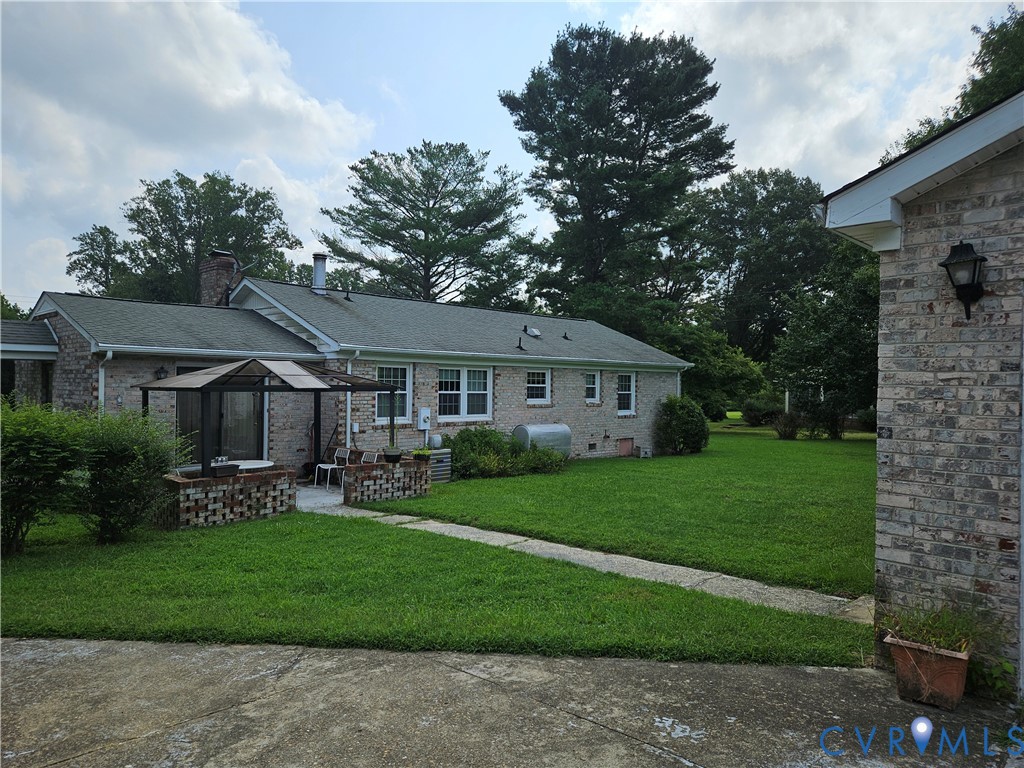 Ranch-style home featuring a gazebo, a front lawn,