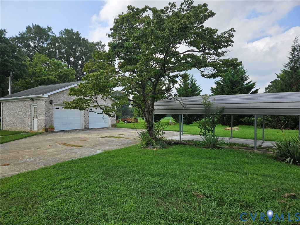 View of grassy yard with a garage